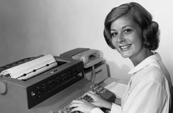 Frau sitzt vor einer alten Schreibmaschine